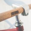 Wooden bicycle handlebar with "Futura" branding, close-up shot.